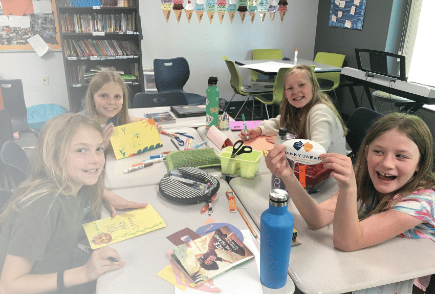 Four girls at Des Moines Christian making Letters of Encouragement for kids with cancer and Pinky Swear Foundation