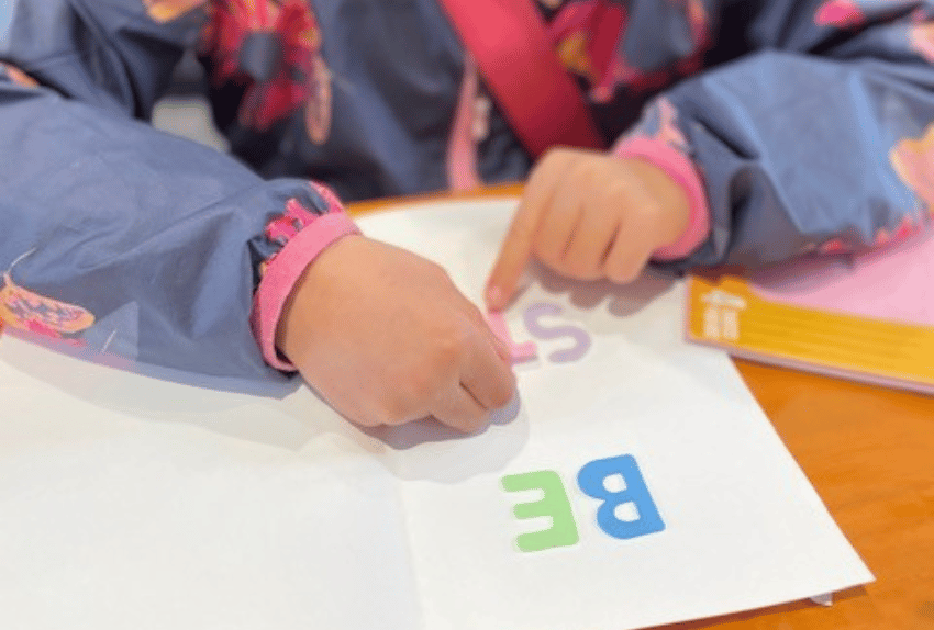 A child putting letters on a card to a kid with cancer.